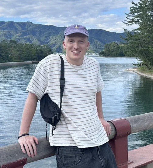 Davide Michelon sulle rive di un lago tra le montagne